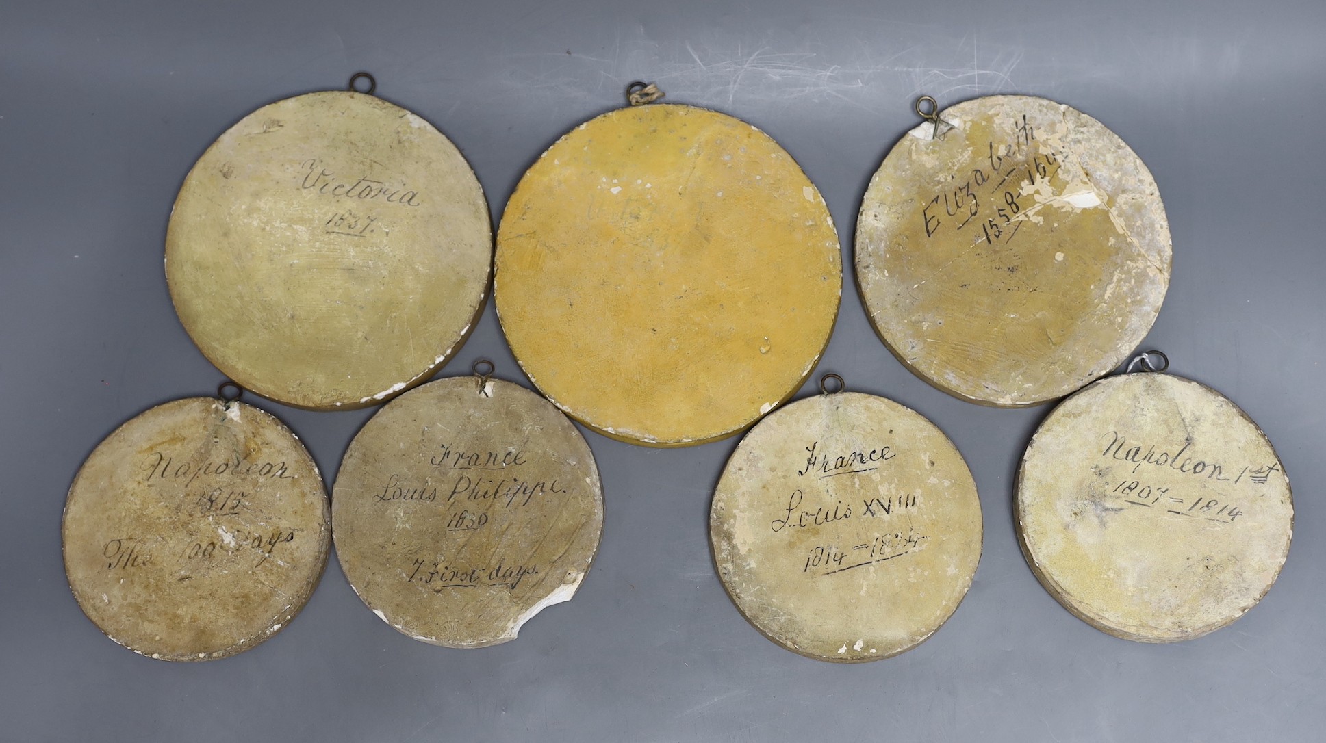 Two Napoleonic commemorative plaster roundels, a Louis VIll, a Louis Philippe, a Queen Elizabeth l and two of Queen Victoria, largest 16,5 cms diameter